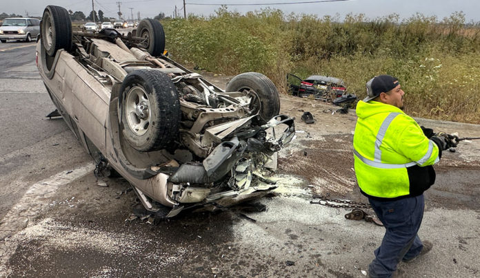 Flipped car Flipped car, wheels up in the air, with a transportation worker on the scene
