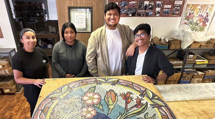 Community Mosaic Projects Move Forward Four young people standing behind a round mosaic artwork