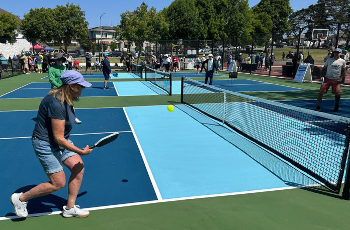 People playing pickleball outdoors on a freshly built court