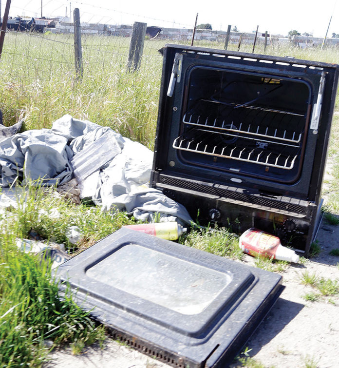 Illegally dumped stove Broken stove tossed along the road in a scenic landscape