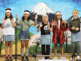 Five children performing on stage