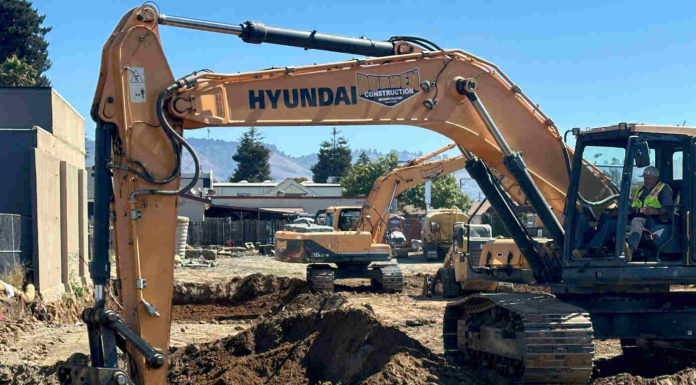 Work crews dig the foundation for a new apartment building on Main Street.